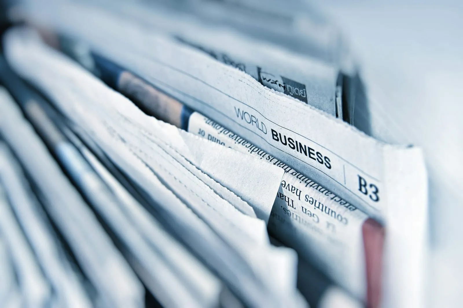 Stack of folded newspapers with the business section on top