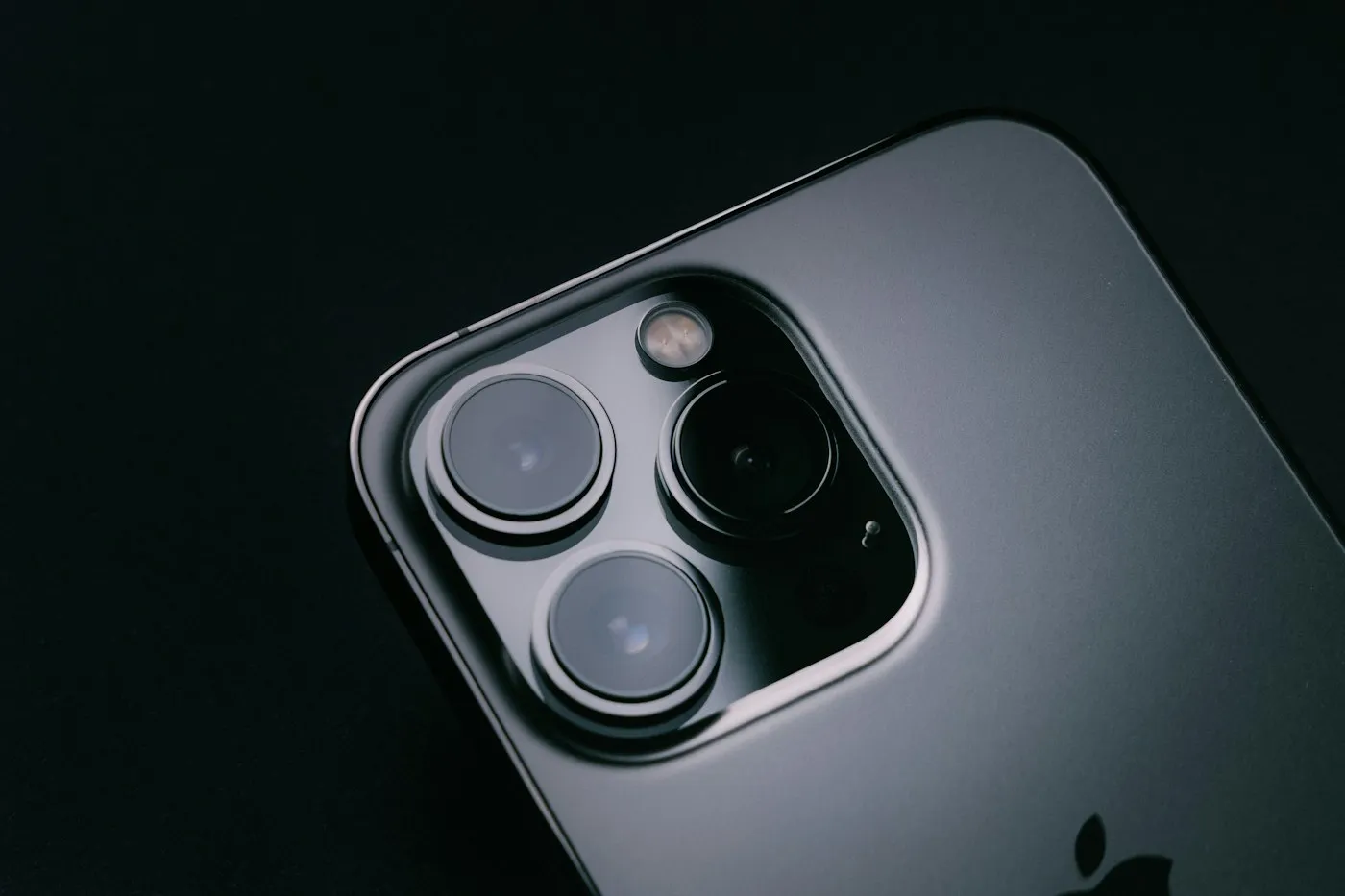 Macro close-up of a graphite smartphone triple rear camera and flash